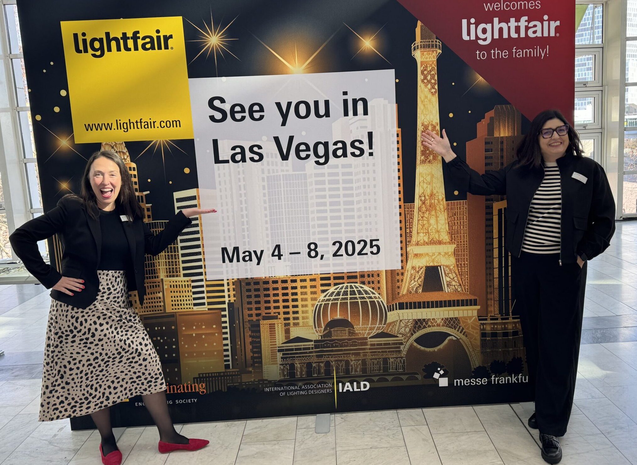 Julie Nickel & Kristy Meade pose next to the LightFair 2025 sign